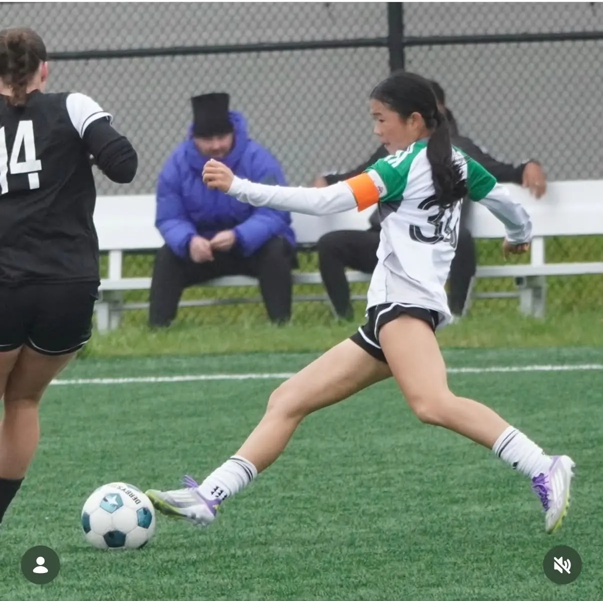Angelina reaching for the ball during a rainy match