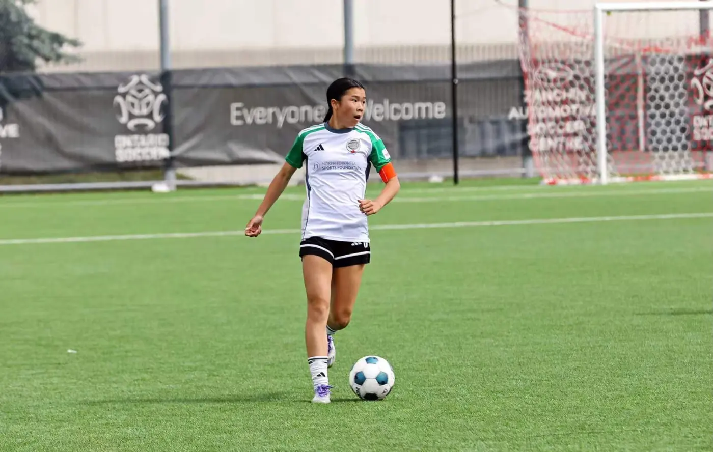Angelina running with the ball on an outdoor field
