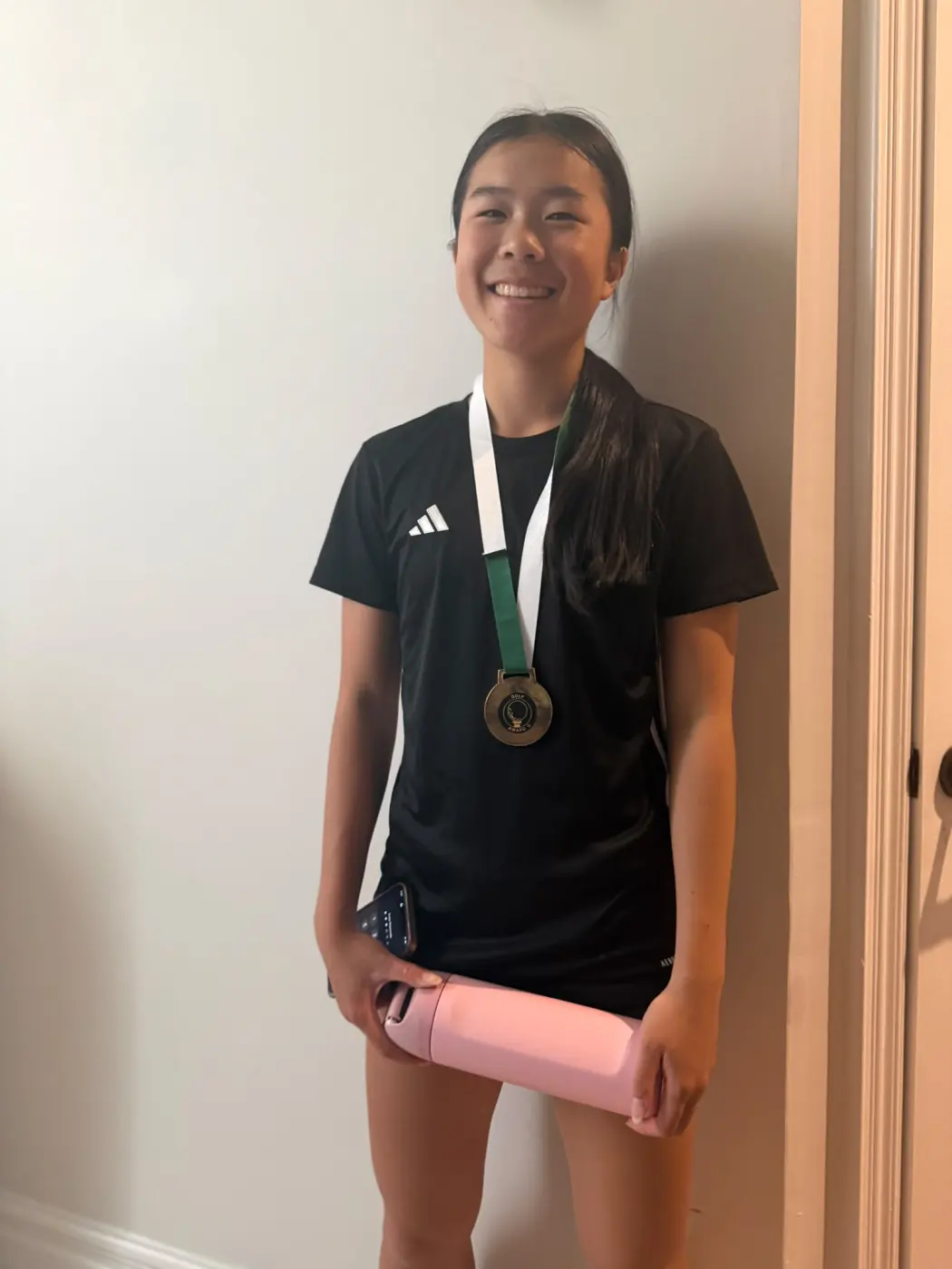 Angelina smiling while wearing a soccer medal